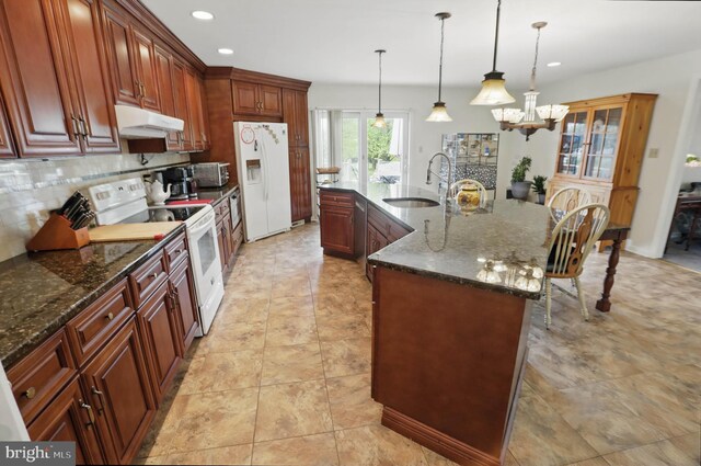 kitchen featuring white appliances, a sink, under cabinet range hood, decorative backsplash, and recessed lighting
