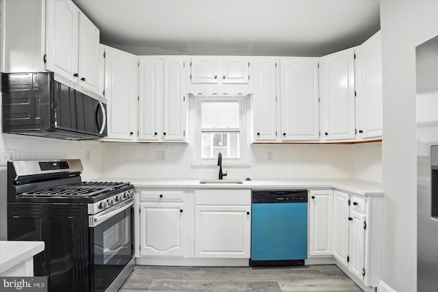 4911 Fox St, College Park, MD 20740 - kitchen with dishwashing machine, a sink, stainless steel range with gas stovetop, white cabinets, and light wood-style floors