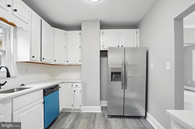 4911 Fox St, College Park, MD 20740 - kitchen with a sink, dishwashing machine, stainless steel fridge, light wood-style floors, and white cabinets
