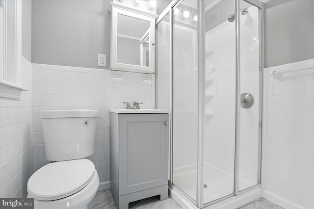 4911 Fox St, College Park, MD 20740 - full bath featuring a stall shower, tile walls, toilet, marble finish floor, and a wainscoted wall
