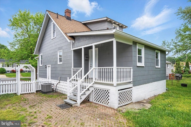 4911 Fox St, College Park, MD 20740 - view of front of house with a chimney, fence, central air condition unit, a porch, and a front lawn