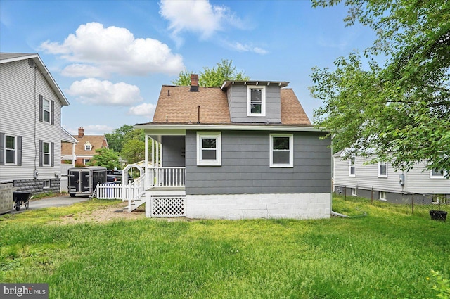 4911 Fox St, College Park, MD 20740 - back of property featuring a yard, fence, a shingled roof, and a chimney