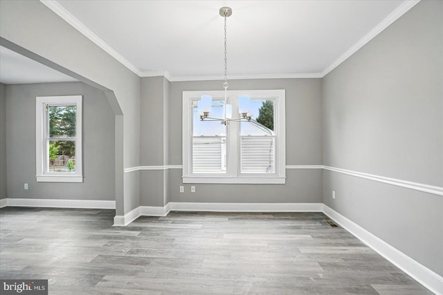 4911 Fox St, College Park, MD 20740 - unfurnished dining area featuring baseboards, ornamental molding, a chandelier, wood finished floors, and arched walkways