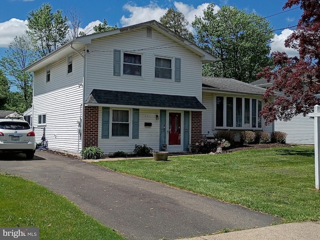 tri-level home with a front lawn and a shingled roof