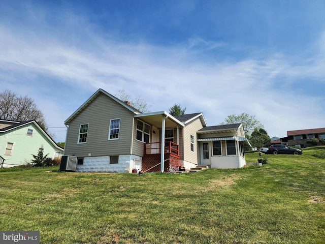 back of property with a chimney and a lawn