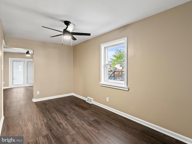 unfurnished room featuring a ceiling fan, baseboards, dark wood finished floors, and visible vents