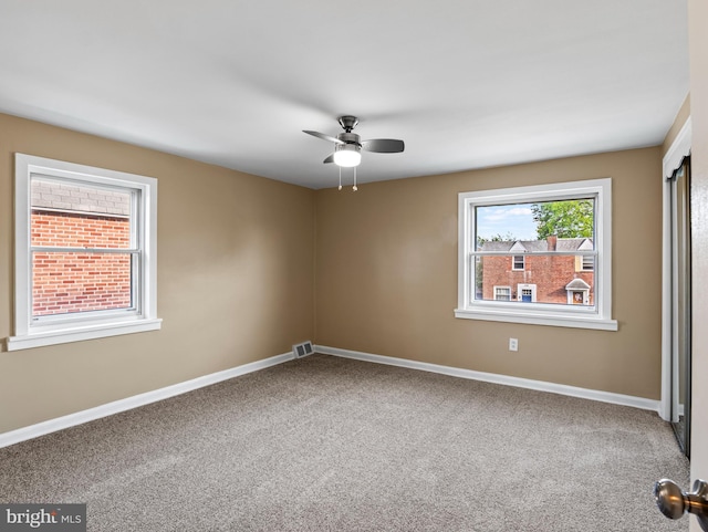 empty room with a ceiling fan, baseboards, visible vents, and carpet floors
