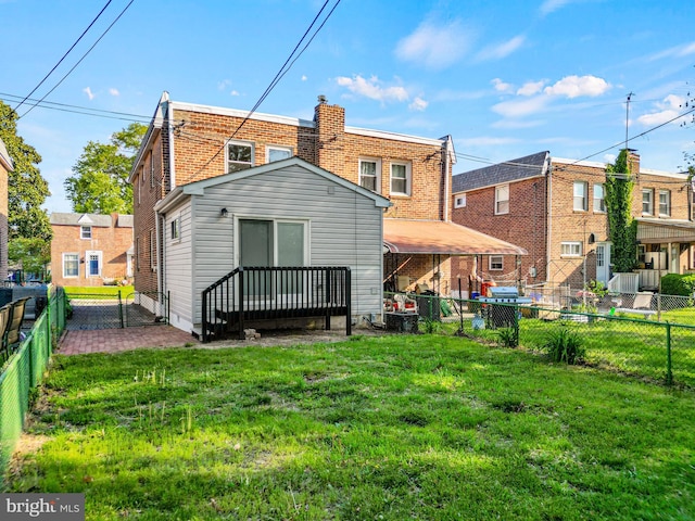 back of property featuring a lawn and a fenced backyard