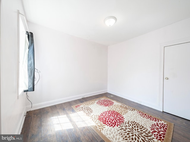 unfurnished room with wood finished floors and baseboards