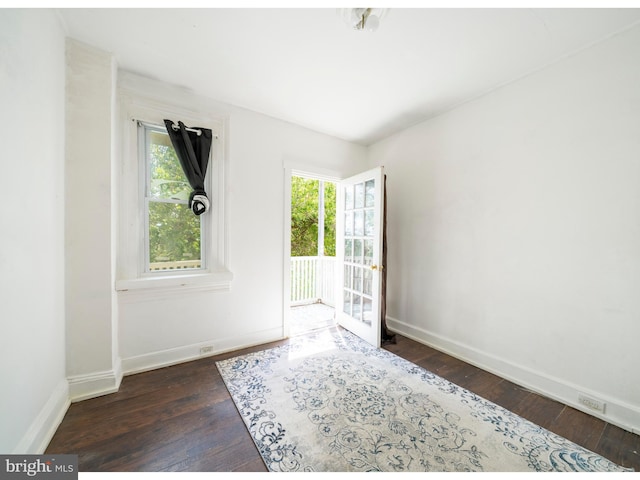 empty room with hardwood / wood-style floors and baseboards
