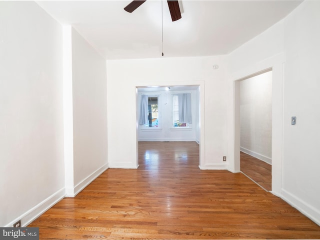 spare room with a ceiling fan, baseboards, and light wood finished floors
