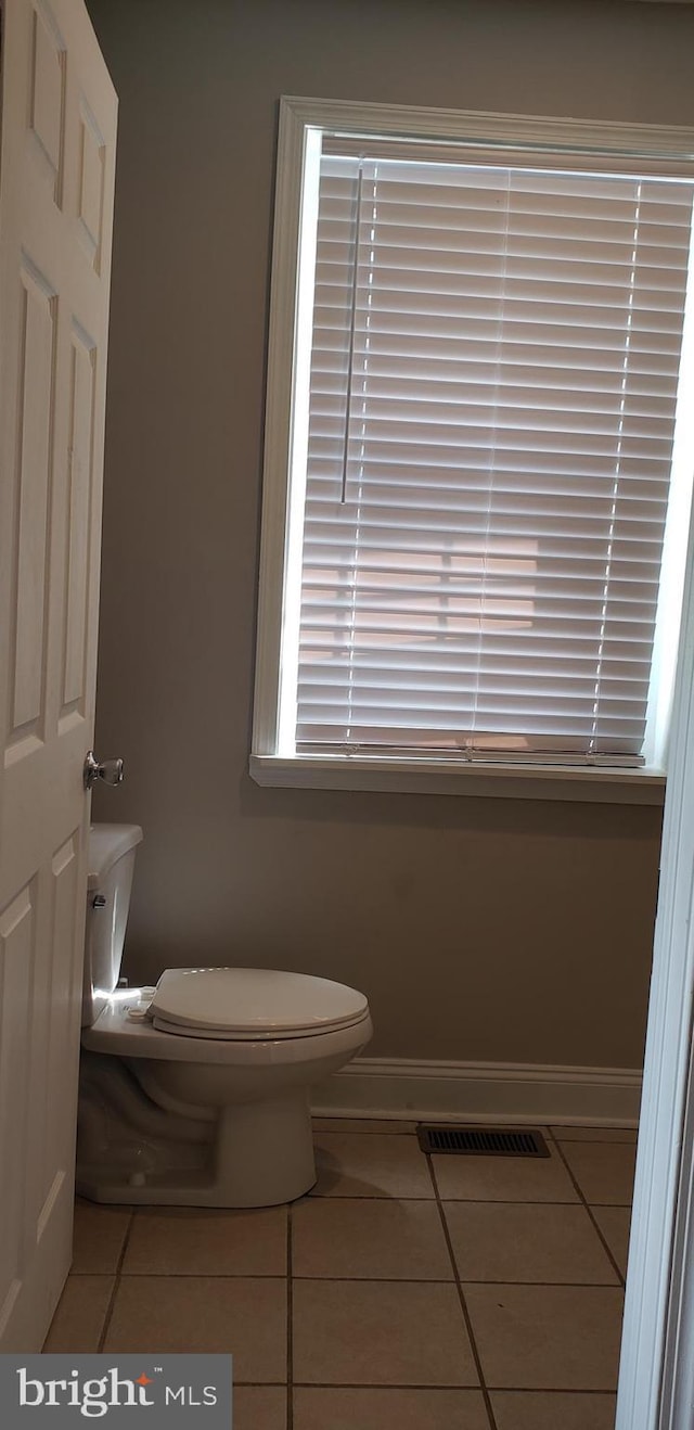 bathroom with toilet, baseboards, tile patterned floors, and visible vents