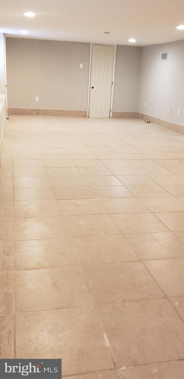 empty room with light tile patterned floors, visible vents, and recessed lighting