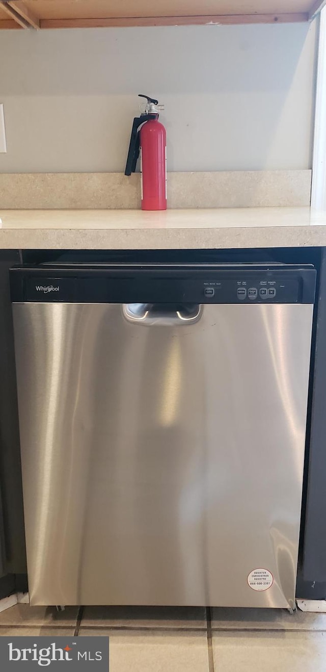 room details with light countertops, a fire extinguisher, and stainless steel dishwasher