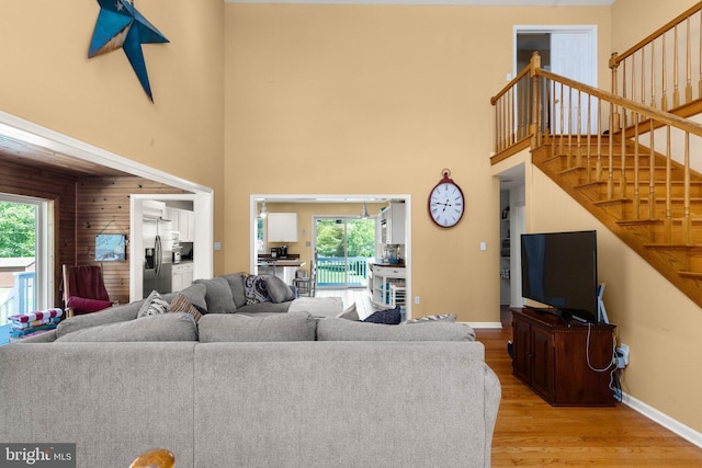 21 Heisler Ave, Charlestown, MD 21914 - living area with light wood-style floors, a high ceiling, stairway, baseboards, and wood walls