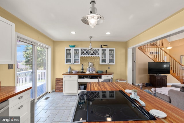 21 Heisler Ave, Charlestown, MD 21914 - kitchen with wood counters, cooktop, white cabinetry, glass insert cabinets, and pendant lighting