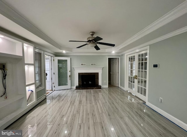 18 River Ln, Levittown, PA 19055 - unfurnished living room with french doors, a tray ceiling, crown molding, light wood-style flooring, and a ceiling fan