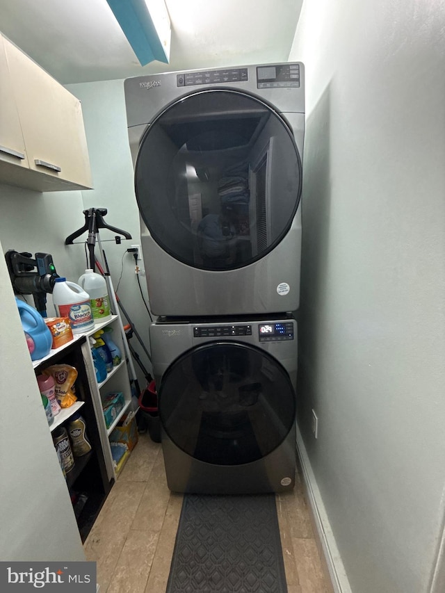 18 River Ln, Levittown, PA 19055 - washroom featuring stacked washer / dryer, cabinet space, and light tile patterned flooring