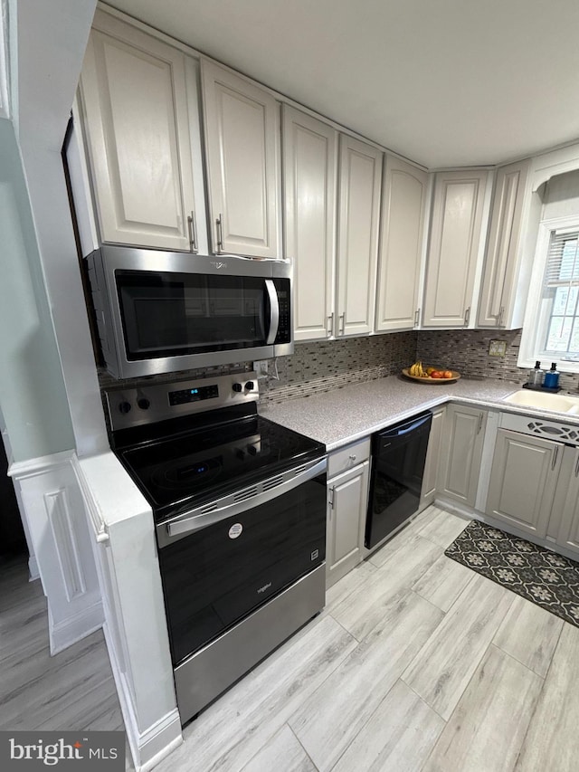18 River Ln, Levittown, PA 19055 - kitchen with appliances with stainless steel finishes, a sink, light wood-style floors, and light countertops