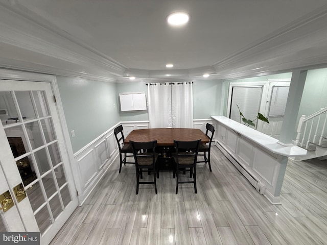 18 River Ln, Levittown, PA 19055 - dining room with crown molding, a decorative wall, a baseboard radiator, a tray ceiling, and light wood-type flooring
