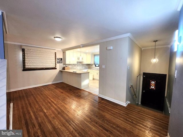 102 Suburban Ter, Stratford, NJ 08084 - kitchen featuring a peninsula, white cabinets, wood finished floors, ornamental molding, and light countertops