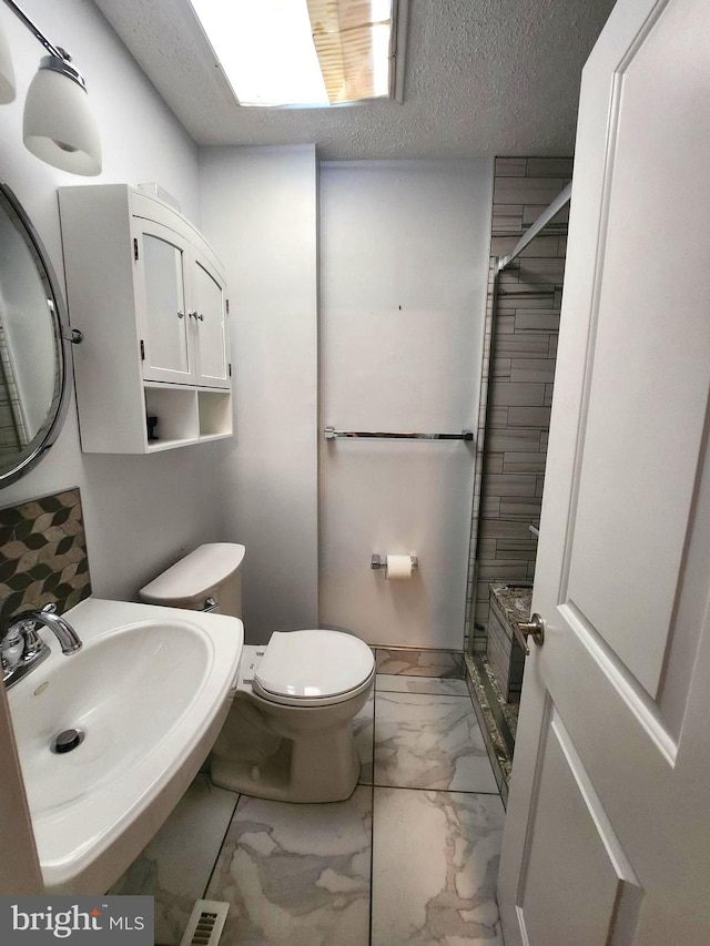 102 Suburban Ter, Stratford, NJ 08084 - bathroom featuring marble look tiles, tiled shower, and a textured ceiling
