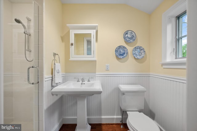 bathroom featuring a shower stall, a wainscoted wall, toilet, wood finished floors, and lofted ceiling