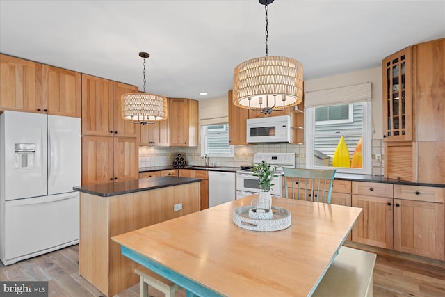 113 Henlopen Dr, South Bethany, DE 19930 - kitchen featuring white appliances, a sink, a kitchen island, light wood-style flooring, and dark countertops