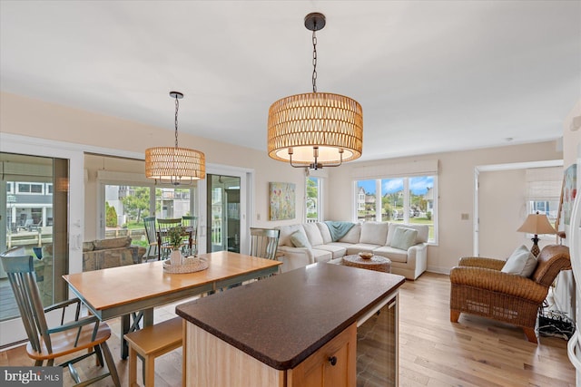113 Henlopen Dr, South Bethany, DE 19930 - kitchen with beverage cooler, a chandelier, dark countertops, light wood-style floors, and open floor plan