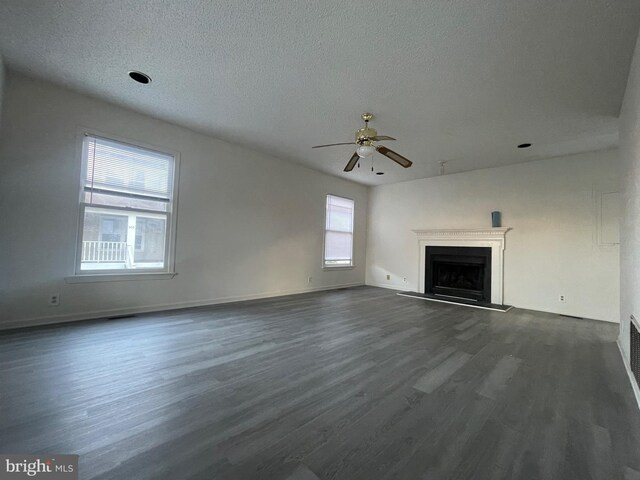 409 Connecticut Ave, Norfolk, VA 23508 - unfurnished living room with a textured ceiling, dark wood-type flooring, baseboards, ceiling fan, and a fireplace with raised hearth