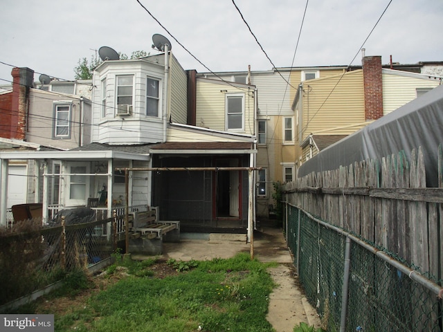 rear view of house with a fenced backyard