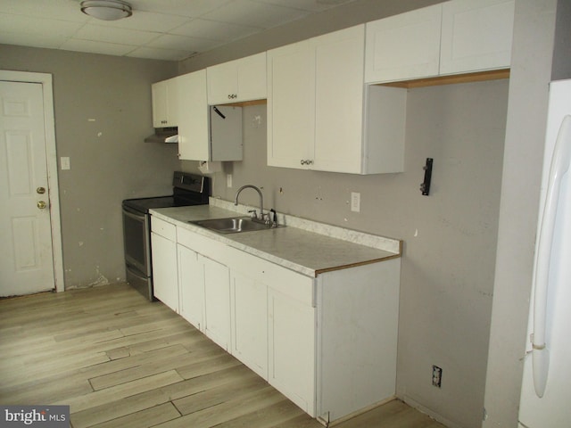 kitchen featuring under cabinet range hood, light wood-type flooring, a sink, and electric stove