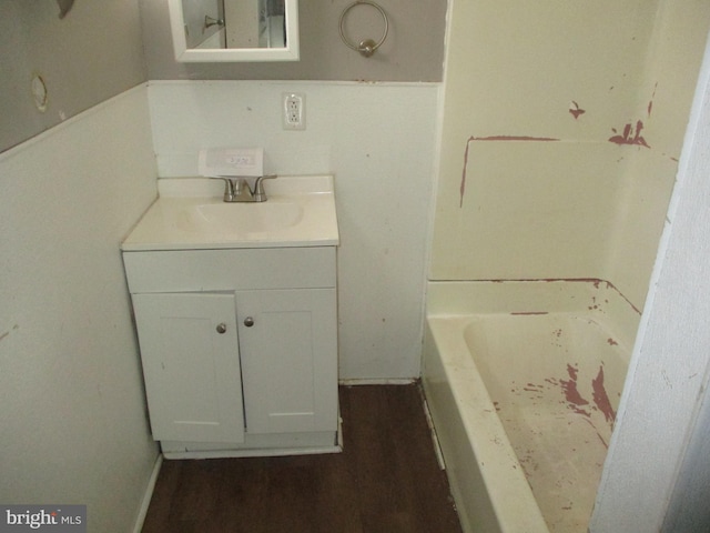bathroom with vanity, wood finished floors, and a washtub