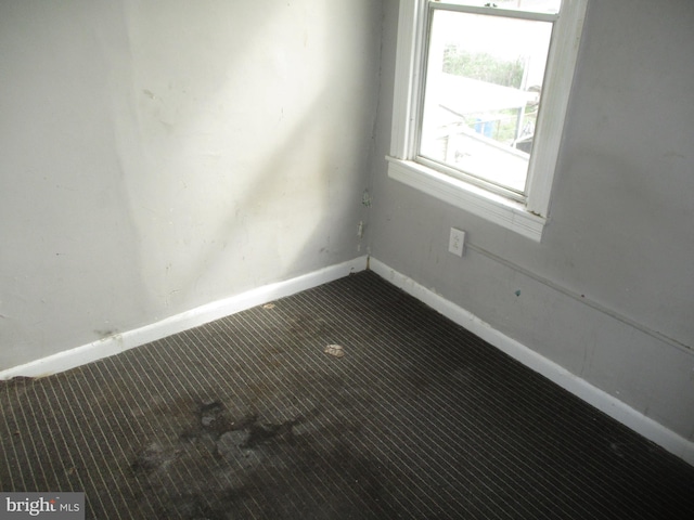 unfurnished room featuring carpet floors and baseboards