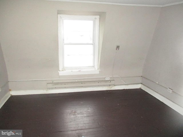 spare room with crown molding, a baseboard radiator, baseboards, and hardwood / wood-style floors