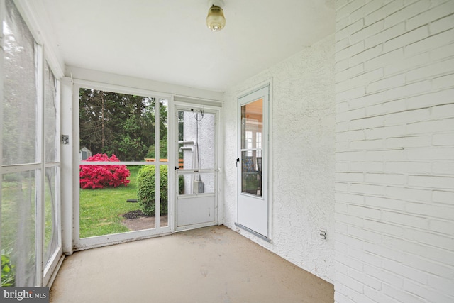 unfurnished sunroom with healthy amount of natural light and concrete flooring