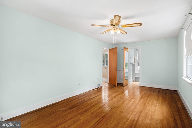 empty room with light wood-style floors, ceiling fan, and baseboards