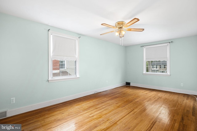 empty room featuring wood finished floors, ceiling fan, and baseboards