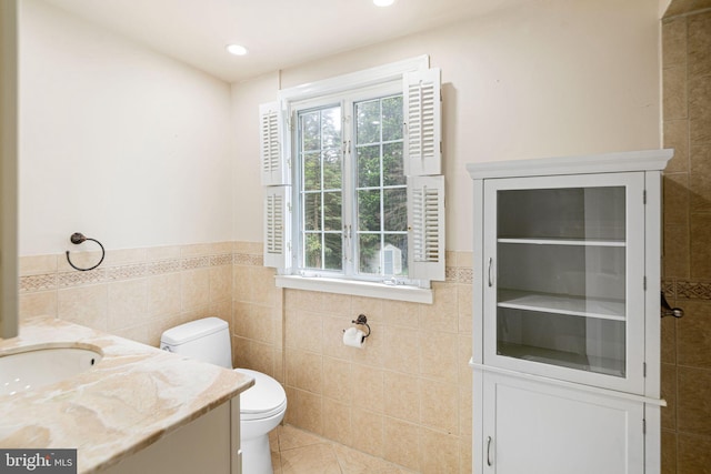 bathroom featuring tile walls, tile patterned floors, toilet, wainscoting, and recessed lighting
