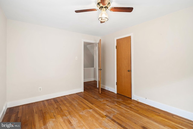 empty room with baseboards, light wood-style floors, and a ceiling fan