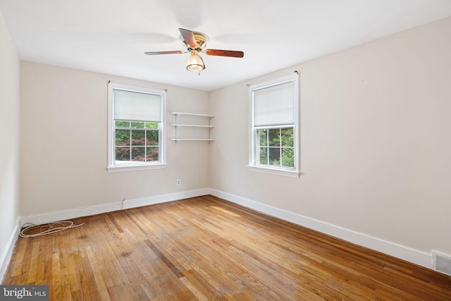 unfurnished room with plenty of natural light, baseboards, and hardwood / wood-style flooring