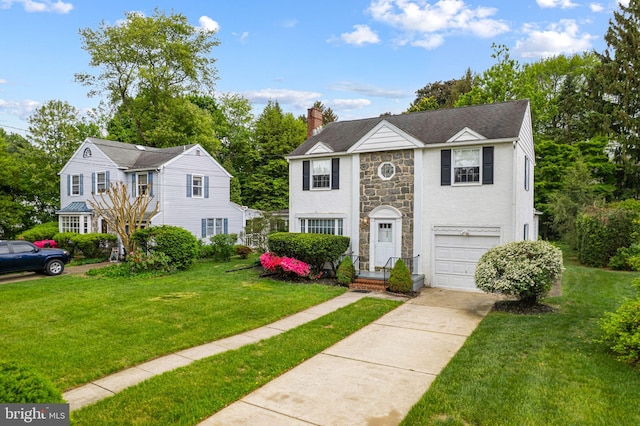 view of front of home with stone siding, driveway, a chimney, an attached garage, and a front yard