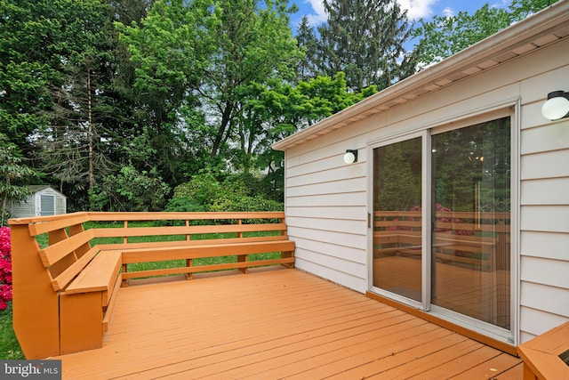 deck featuring a storage shed and an outdoor structure
