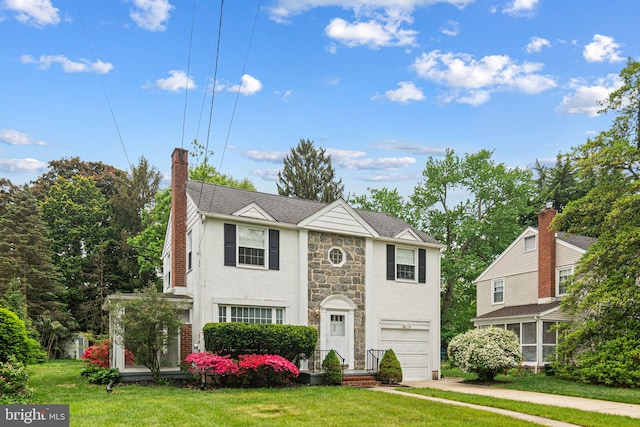 view of front facade featuring a garage, a chimney, concrete driveway, stone siding, and a front lawn