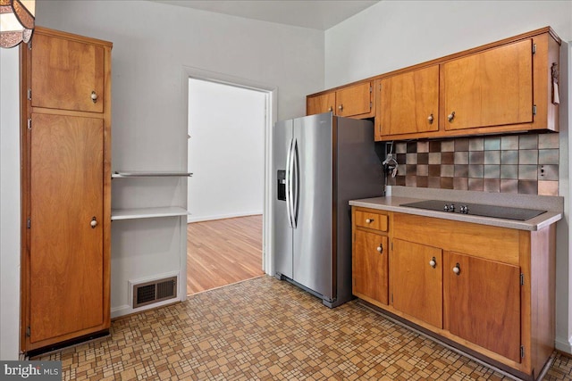 8815 Beauchamp Dr, Alexandria, VA 22309 - kitchen featuring stainless steel fridge, black electric stovetop, tasteful backsplash, light flooring, and light countertops