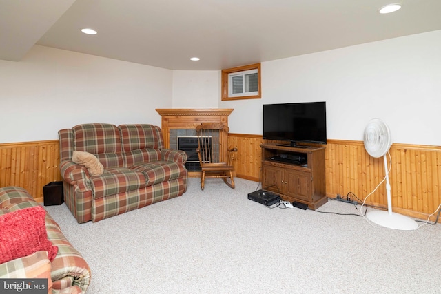 living room with recessed lighting, carpet, a glass covered fireplace, wood walls, and a wainscoted wall