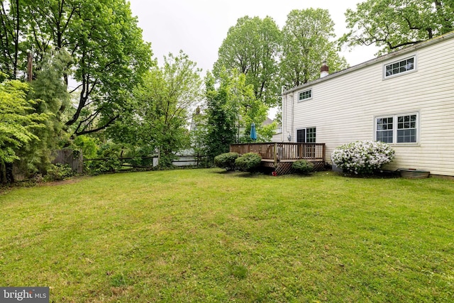 view of yard featuring fence and a deck