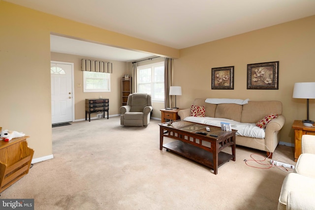 living area with light carpet and baseboards