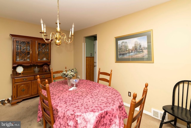 dining area featuring light carpet, a chandelier, and visible vents
