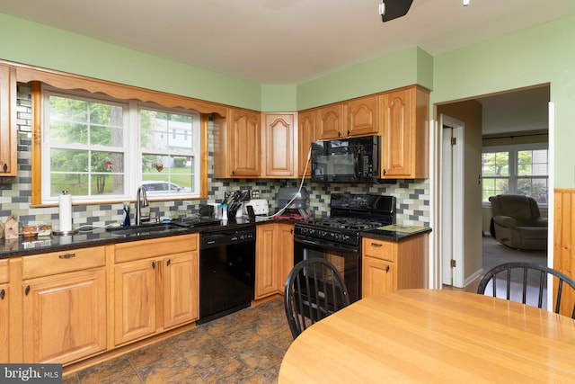kitchen featuring black appliances, decorative backsplash, and a sink